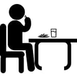 man-sitting-in-front-of-a-table-eating-and-drinking-while-having-lunch_318-62566